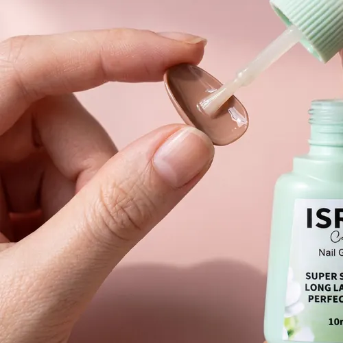 Brushing Isra Nail Glue onto the back of a press-on nail